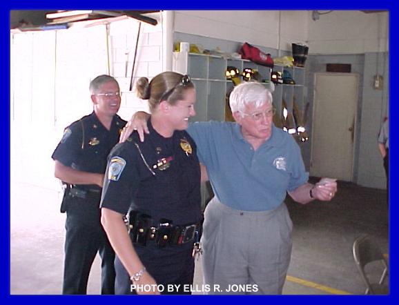 PHOTO TAKEN 14 JULY 06
OFFICE LAURA WILLIS (LEFT) COMPLIMENTED.
POLICE CHIEF JEFF CLARK (REAR) LOOKS ON APPROVINGLY. 